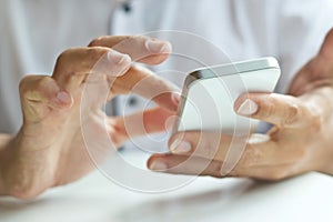 Close up of a man using white mobile smart phone