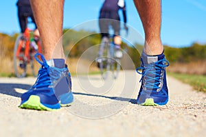 Close up of man walking in nature with biker in background