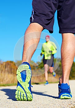 Close up of man walking in nature with jogger in background