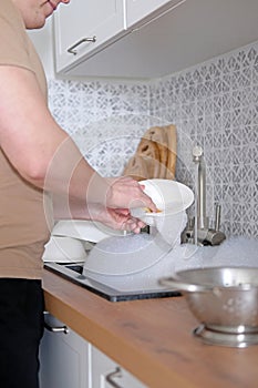 Close-up of a man washing dishes in the kitchen sink