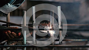 Close-up: man welding a pipe to the construction