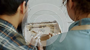 Close-up of man and woman couple making bowl on potter`s wheel together