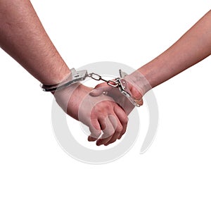 Close up of man and woman holding hands in handcuffs - relationship concept