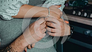 Close-up man and woman holding hands in the kitchen