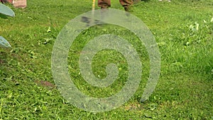 Close up of man working with trimmer cutting grass