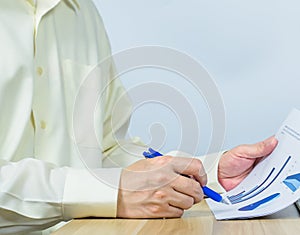 close up man writing on document data graph on working desk