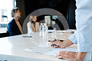 Close up of man writing down notes during meeting in office