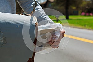 Close-up Of Man& x27;s Hand Taking Letter From Mailbox Outside House