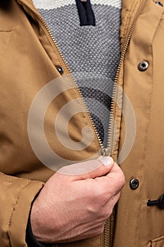 Close-up of man zipping winter jacket