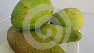 Close up of mangoes on a White background. It is the national fruit of India and Pakistan, and the national tree of Bangladesh