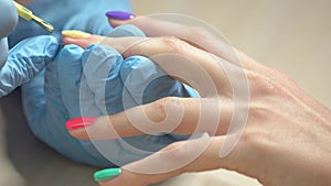 Close up manicurist applying nail varnish.