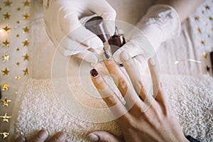 Close-up of manicurist hands in rubber gloves working