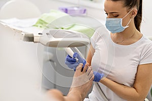 Close-up of manicurist removing cuticle from the nails of feet