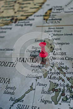 Close up of Manila pin pointed on the world map with a pink pushpin