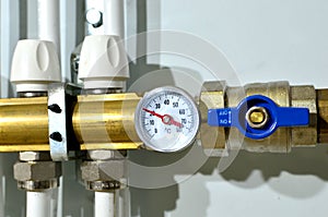 Close up of manometer, pipe, flow meter, water pumps and valves of heating system in a boiler room at home. Systems of water floor