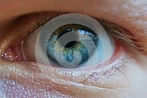 Close up of a mans blue eyes, extrem macro. Reflection of a buildingin the eye.