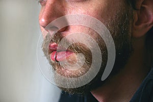 A close up of a mans face with a piercing