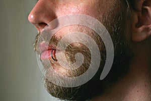 A close up of a mans face with a piercing