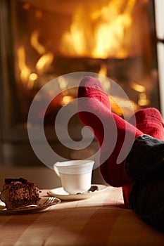 Close Up Of Mans Feet Relaxing By Cosy Log Fire