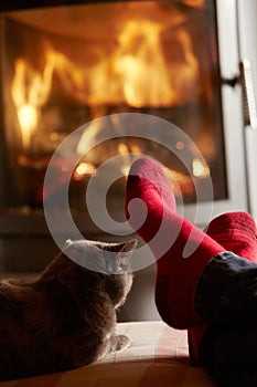 Close Up Of Mans Feet Relaxing by Fire With Cat