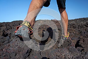 Close-up of mans feet walking on lava field