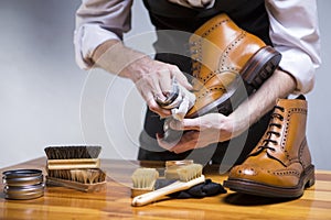 Close Up of Mans Hands Cleaning Luxury Calf Leather Brogues with Special Accessories, Shoe Wax and Tools photo