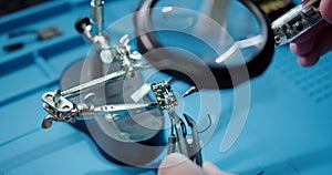 Close-up of a mans hands is soldering the video transmitter chip from FPV drone