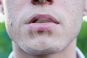 Close up of mans mouth on green background with a smile