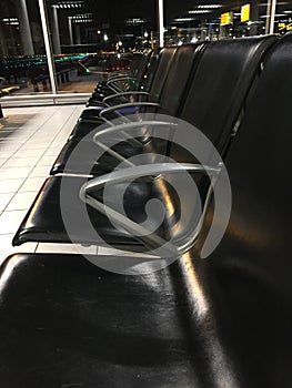 Close up of the many chairs at an empty hall at the airport at night