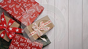 Close-up of many Christmas gifts lying on a white wooden table, top view, flat lay, copy space. Christmas and New Year banner