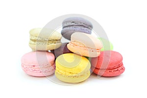 Close up many colorful fresh macarons pile isolated on white background, look delicious