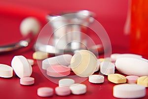 Close up of many colorful pills and capsules on red background