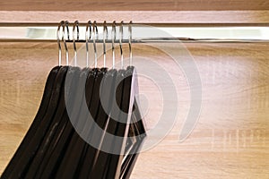 Close-up many empty black clothing racks hanging on coathanger photo