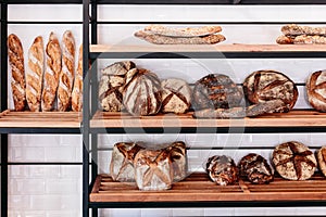 Close up many freshly baked bread on the shelf such as nuage, baguette and spelt bread
