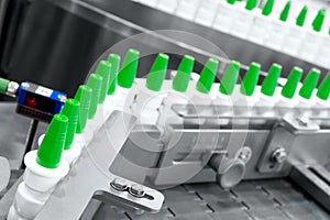 Close-up Many white plastic spray bottles for packaging liquid medicines or cosmetics in a row on a conveyor belt in a pharmaceuti