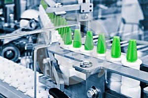 Close-up Many white plastic spray bottles for packaging liquid medicines or cosmetics in a row on a conveyor belt in a pharmaceuti