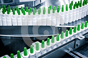 Close-up Many white plastic spray bottles for packaging liquid medicines or cosmetics in a row on a conveyor belt in a pharmaceuti