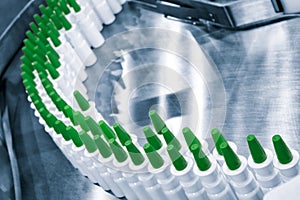 Close-up Many white plastic spray bottles for packaging liquid medicines or cosmetics in a row on a conveyor belt in a pharmaceuti