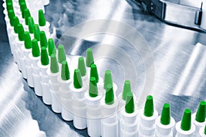 Close-up Many white plastic spray bottles for packaging liquid medicines or cosmetics in a row on a conveyor belt in a pharmaceuti