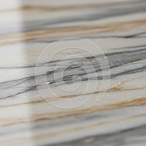 Close-up of a marble surface featuring layered patterns in gray, beige, and brown hues