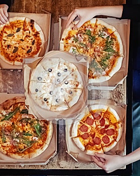 Close-up of Margarita pizza in a disposable dish. Top view of takeaway food in a fast food cafe. On photo - mozzarella cheese,