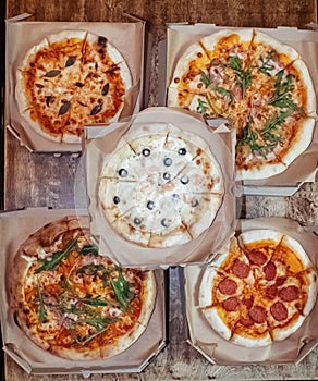 Close-up of Margarita pizza in a disposable dish. Top view of takeaway food in a fast food cafe. On photo - mozzarella cheese,