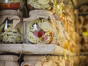 Close up marinated Glass jars with slovak and moravian home made cheese, red peppers and herbs on shelf at christmas