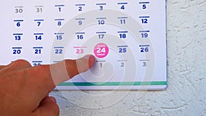 Close-up of the marked Black Friday date on the November page of a calendar 2023 and a man's hand points his finger at it