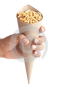 Close up of Marwadi Bhujiya Indian namkeen snacks  in brown paper cone holding in hand isolated over white