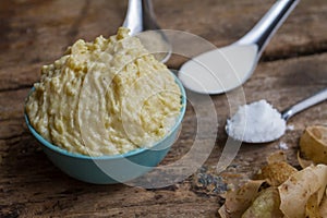 Close up of Mashed potatoes in a blue cup prepared on a wooden table and decorative items