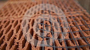 Close-up masonry of red brick blocks in process of construction. Stock footage. Red ceramic brick blocks for building