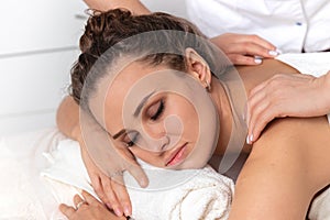 Close-up massage and body care in spa salon for young woman, beautiful girl with closed eyes enjoying treatment procedure, concept