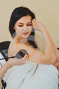 Close-up of massage with special ultrasonic device on female hand. Ð¡osmetic treatments