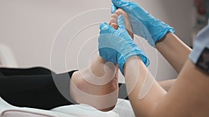 Close up of masseur doing foot reflexology massage to woman at beauty salon